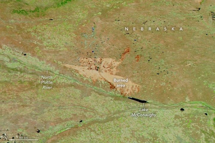 A burned area on the plains of western Nebraska appears as a large tan area in a false-color satellite image.